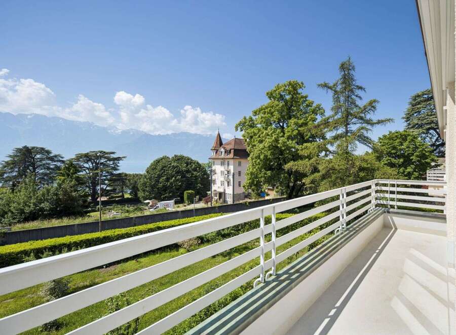 Enjoy breathtaking panoramic views from this stunning balcony, overlooking a serene lake and majestic mountains.