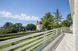 Enjoy breathtaking panoramic views from this stunning balcony, overlooking a serene lake and majestic mountains.