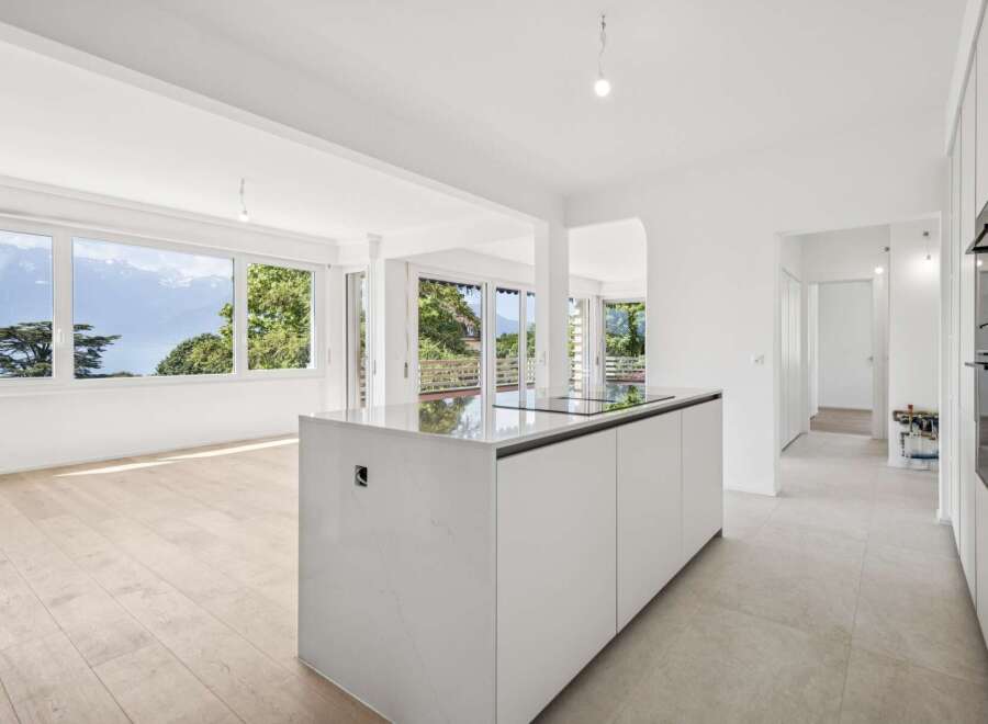 Experience breathtaking panoramic views of mountains and a serene lake from this stunning modern kitchen.