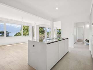 Experience breathtaking panoramic views of mountains and a serene lake from this stunning modern kitchen.