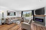 Experience breathtaking mountain views from this stunning living room, featuring a spacious sectional sofa and a modern electric fireplace.