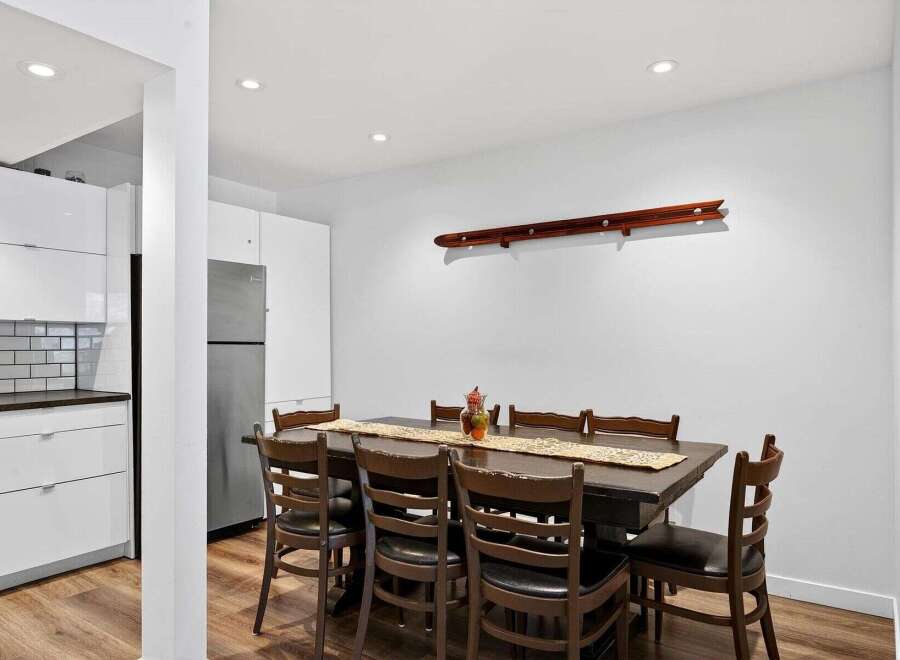 This spacious dining area features a large, dark wood table with eight matching chairs, perfect for family gatherings.