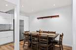 This spacious dining area features a large, dark wood table with eight matching chairs, perfect for family gatherings.