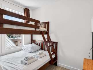 This charming bedroom features a space-saving bunk bed, perfect for families or accommodating guests.