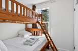 This cozy bedroom features a sturdy wooden bunk bed, perfect for families or accommodating guests.
