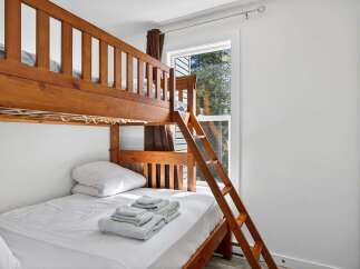 This cozy bedroom features a sturdy wooden bunk bed, perfect for families or accommodating guests.