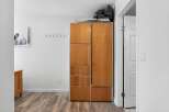 This hallway features a tall wooden cabinet with multiple storage compartments, perfect for organizing your belongings.