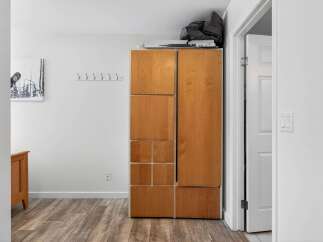 This hallway features a tall wooden cabinet with multiple storage compartments, perfect for organizing your belongings.