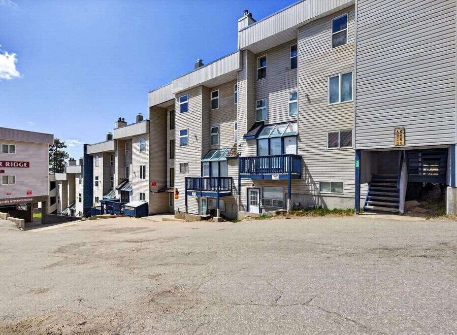 Discover this multi-unit residential building featuring a light-colored exterior with horizontal siding and multiple balconies.