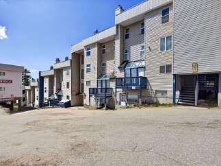 Discover this multi-unit residential building featuring a light-colored exterior with horizontal siding and multiple balconies.