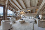 Experience luxurious mountain living in this stunning chalet living room, featuring a plush sectional sofa and cozy armchairs perfect for relaxing.