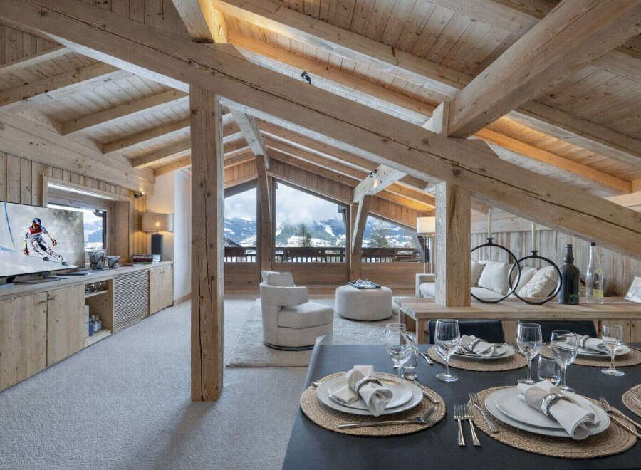 Experience luxury mountain living in this stunning chalet, featuring exposed wooden beams and panoramic views of snow-capped peaks.