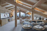 Experience luxury mountain living in this stunning chalet, featuring exposed wooden beams and panoramic views of snow-capped peaks.