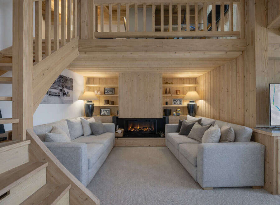 Experience ultimate comfort in this stunning living room, featuring two plush sofas facing a modern fireplace.