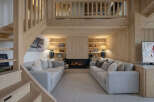 Experience ultimate comfort in this stunning living room, featuring two plush sofas facing a modern fireplace.
