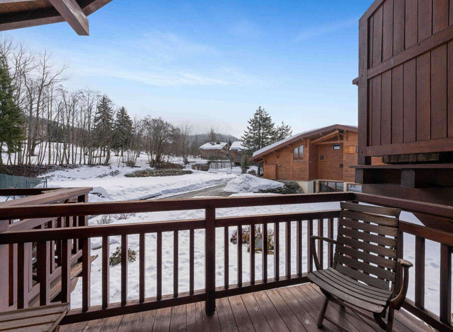 Experience the charm of a winter wonderland from this inviting balcony, offering picturesque views of snow-covered landscapes and traditional wooden chalets.