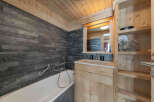 Experience rustic charm in this bathroom featuring a deep soaking tub set against a striking slate tile wall.