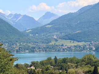 Experience breathtaking panoramic views of a serene lake and majestic mountains from this stunning property.