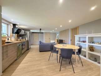 Discover this modern open-concept living space, featuring a sleek kitchen with stainless steel appliances and ample cabinet storage.