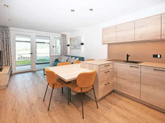 Experience modern living in this beautifully appointed apartment, featuring a sleek, open-plan kitchen with ample cabinet space and a stylish dining area perfect for entertaining.