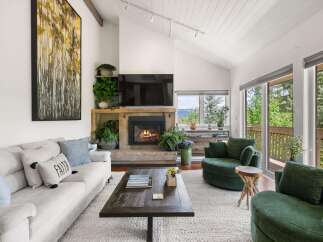 Experience cozy living in this inviting living room, featuring a stone fireplace and a large sectional sofa perfect for gatherings.