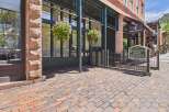 Discover the charm of this historic hotel, featuring a classic brick exterior and a welcoming entrance adorned with vibrant hanging flower baskets.