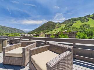 Enjoy breathtaking mountain views from this stunning deck, complete with comfortable seating and a relaxing hot tub.