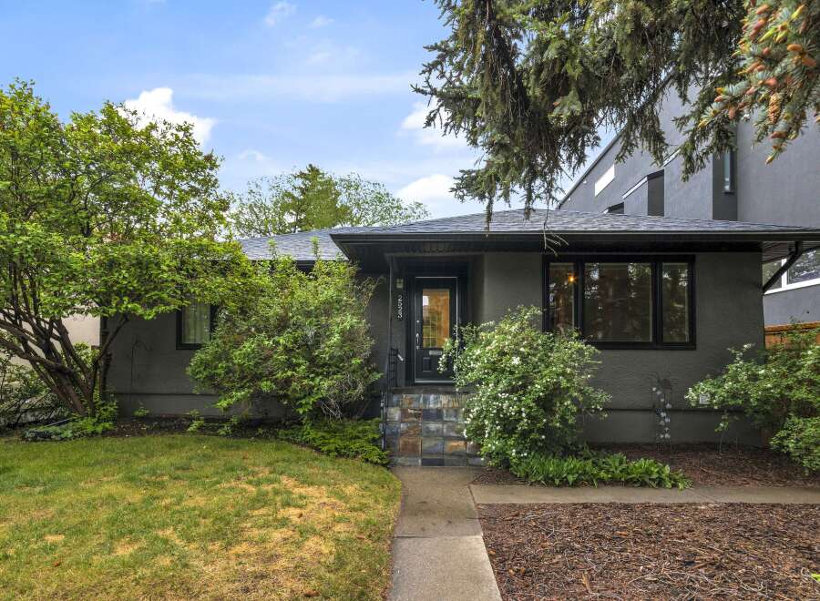 Charming single-family home with a welcoming entrance featuring a black door and multi-colored tile steps.