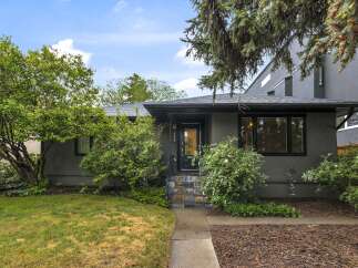 Charming single-family home with a welcoming entrance featuring a black door and multi-colored tile steps.