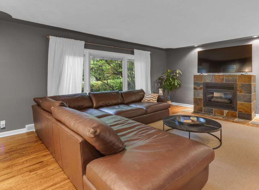 Experience comfort and style in this inviting living room, featuring a luxurious brown leather sectional sofa perfect for family gatherings.
