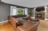 Experience comfort and style in this inviting living room, featuring a luxurious brown leather sectional sofa perfect for family gatherings.