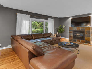 Experience comfort and style in this inviting living room, featuring a luxurious brown leather sectional sofa perfect for family gatherings.