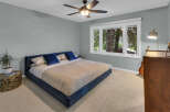 Experience comfort and style in this serene bedroom, featuring a plush navy blue bed and soft, neutral carpeting.