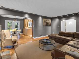 Step into this inviting living space featuring a plush brown leather sectional sofa perfect for relaxation and entertainment.