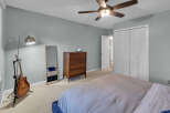 This bedroom features a comfortable bed with a textured duvet, a wooden dresser, and a full-length mirror.