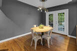 This dining area features a charming round wooden table with four white metal chairs, perfect for intimate meals.