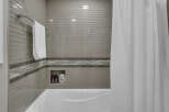 Experience modern elegance in this bathroom featuring a sleek subway tile shower surround and a decorative accent band.