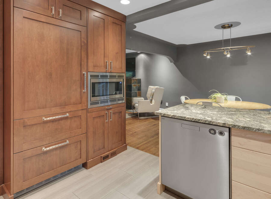 Discover this stunning kitchen featuring sleek, custom wood cabinetry and a built-in stainless steel microwave.