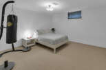 This bedroom offers a unique blend of relaxation and fitness with a comfortable bed and a professional-grade Everlast punching bag.