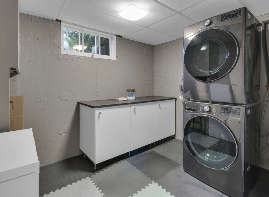 This laundry room features a stacked LG washer and dryer set, offering a space-saving solution.