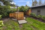 Experience ultimate relaxation in this backyard oasis featuring a charming wooden hot tub, perfect for unwinding after a long day.