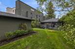 Discover this modern home with a sleek, dark exterior and a spacious backyard perfect for entertaining.
