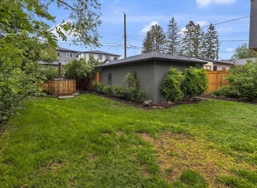 Enjoy ultimate relaxation in this backyard oasis, featuring a charming wooden hot tub perfect for unwinding.