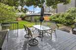 Enjoy outdoor living on this spacious deck, complete with a glass-top dining table and chairs, perfect for al fresco meals.
