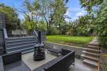 Enjoy outdoor living in this spacious backyard featuring a multi-level deck with seating and a dining area, perfect for entertaining.