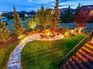 Experience outdoor living at its finest with this beautifully landscaped backyard, featuring a modern fire pit area perfect for gatherings.