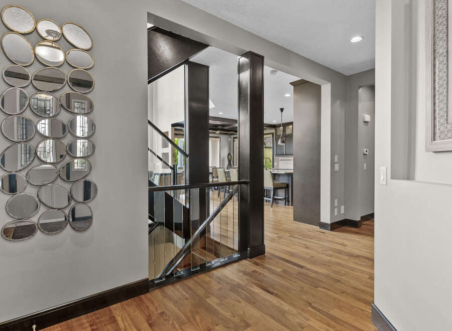Step into a grand foyer featuring a striking wall of eclectic mirrors that add depth and dimension.