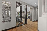 Step into a grand foyer featuring a striking wall of eclectic mirrors that add depth and dimension.