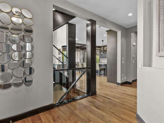 Step into a grand foyer featuring a striking wall of eclectic mirrors that add depth and dimension.