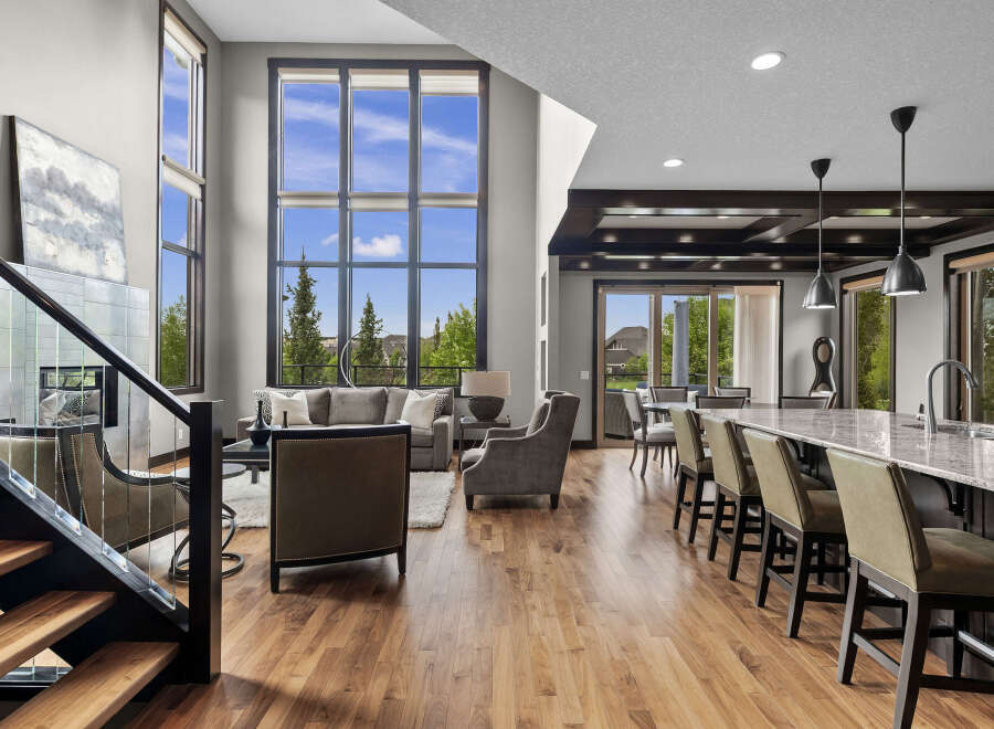 Experience luxury living in this stunning open-concept home featuring a grand living area with soaring ceilings and a wall of windows offering breathtaking views.